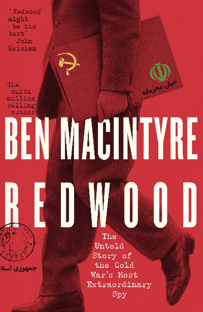 Book cover for 'Redwood' by Ben Macintyre, featuring a red-tinted photograph of a person in a suit holding a folder with a Soviet hammer-and-sickle emblem and an Iranian flag, with large white title text over a red background.