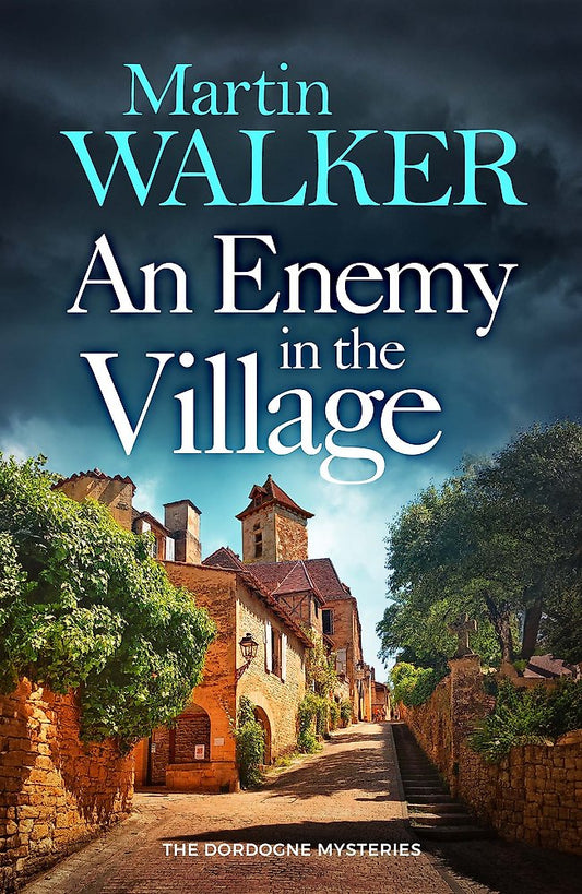 Book cover of 'An Enemy in the Village' by Martin Walker with a village scene.