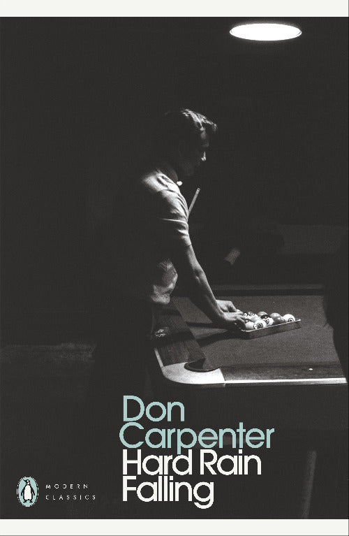 Book cover of 'Hard Rain Falling' by Don Carpenter with a black and white image of a person at a desk.